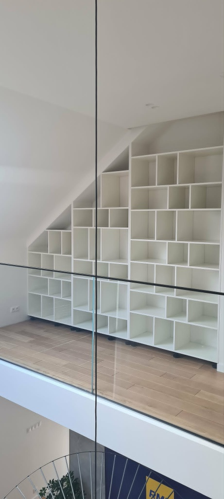 Zabudowa regału pod skosem — biała biblioteczka na wymiar